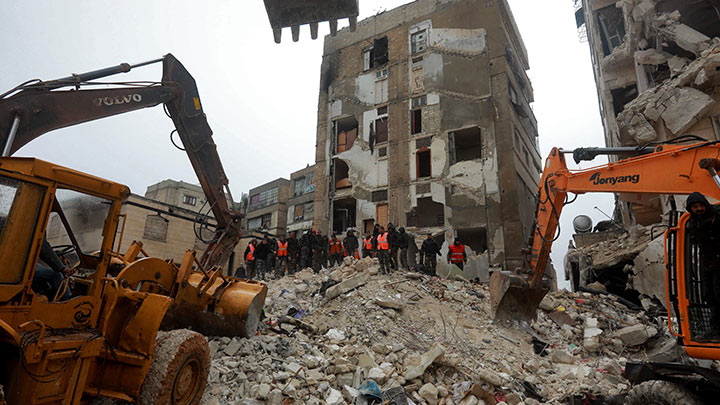 Maquinaria y rescatistas se mueven entre los escombros de un edificio durante la búsqueda de sobrevivientes en Hama./Foto: AFP