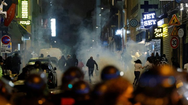 Francia-Manifestantes corren mientras policías usan gases lacrimógenos en París, el 2 de julio. Más de 1.300 personas fueron capturadas