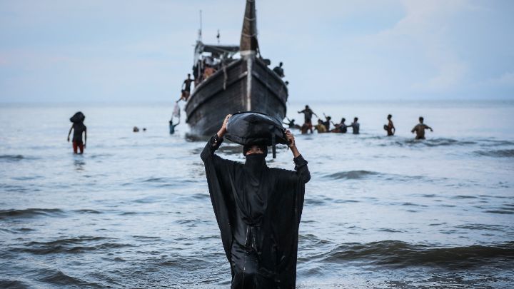 Indonesia-Refugiados caminan hacia la playa después de desembarcar temporalmente en busca de agua y alimentos en Indonesia, el 16 de noviembre. Unas 250 personas llegaron en una embarcación de madera.