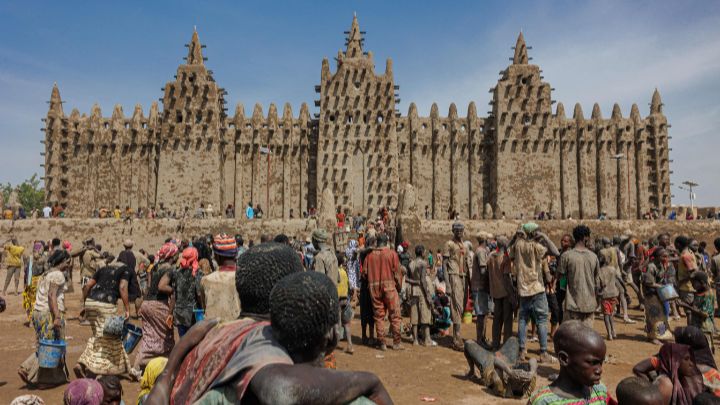 Malí-Cientos de ciudadanos observan la Gran Mezquita de Djenne en el centro de Malí, el 4 de junio. Miles de personas se reúnen cada año para volver a enyesar sus paredes