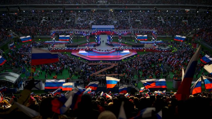 Rusia-Ciudadanos ondean banderas durante el discurso de Vladimir Putin en conmemoración al ‘Día de los defensores de la Patria’, el 22 de febrero