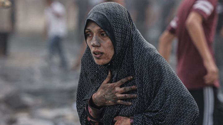 Territorios Palestinos-Una mujer palestina cubierta de polvo, reacciona tras un ataque aéreo israelí contra edificios en Rafah, en el sur de la Franja de Gaza, el 17 de octubre.