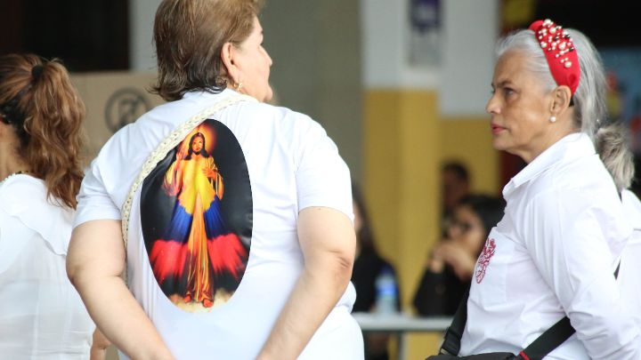 Con el santo  a sus espaldas, así llegó esta mujer a un puesto de votación/Foto Carlos Ramírez/La Opinión