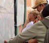 Con lupa, así buscaron su cédula para ubicar la mesa muchos electores en el área metropolitana./Foto Carlos Ramírez/La Opinión