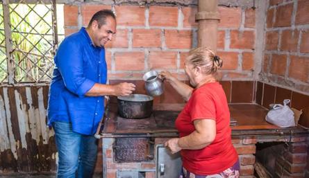 Director de corponor, Gregorio Angarita Lamk, saluda a beneficiaria de las estufas ecoeficientes./Foto cortesía