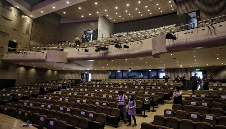 Un teatro de Bogotá abierto con pocas personas y sus sillas en mayoría con carteles que prohíbe sentarse por la situación de pandemia