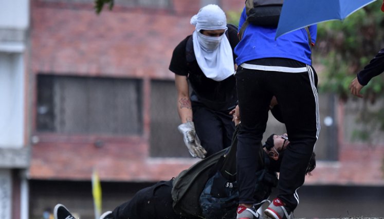 Un hombre ayudado por compañeros manifestantes luego de ser alcanzado por una bala durante enfrentamientos con la Policía. / Foto: AFP