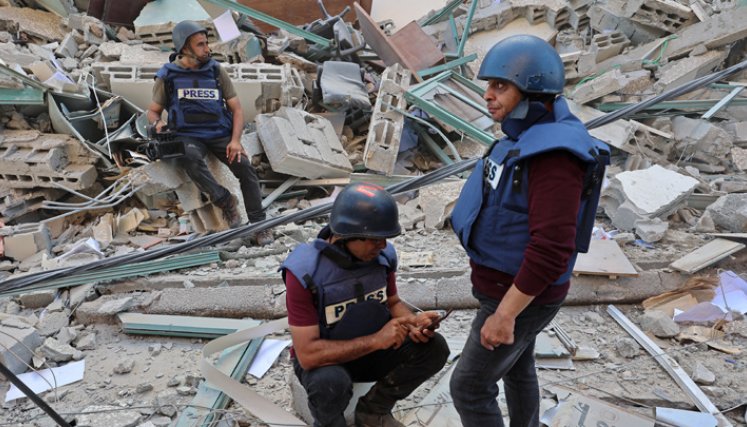 Los periodistas se sientan sobre los escombros de la Torre Jala, que albergaba oficinas de prensa internacionales, luego de un ataque aéreo israelí en la Franja de Gaza. Un ataque aéreo israelí demolió el edificio de 13 pisos que alberga la televisión Al-Jazeera con sede en Qatar y de la Agencia de noticias estadounidense The Associated Press. / Foto: AFP