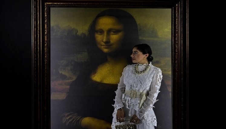  Una mujer posa para fotografías junto a una reproducción del retrato de Lisa Gherardini, esposa de Francesco del Giocondo, conocida como la Mona Lisa o La Gioconda./Foto: AFP