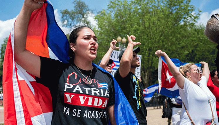 Manifestantes sostienen la bandera cubana mientras protestan frente a la Casa Blanca  En Washington contra el gobierno de la isla. / Foto AFP