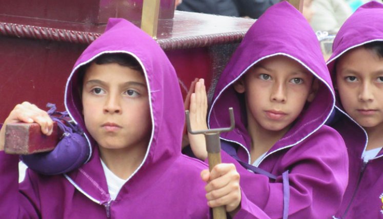 Los nazarenos cargan las andas con las imágenes.
