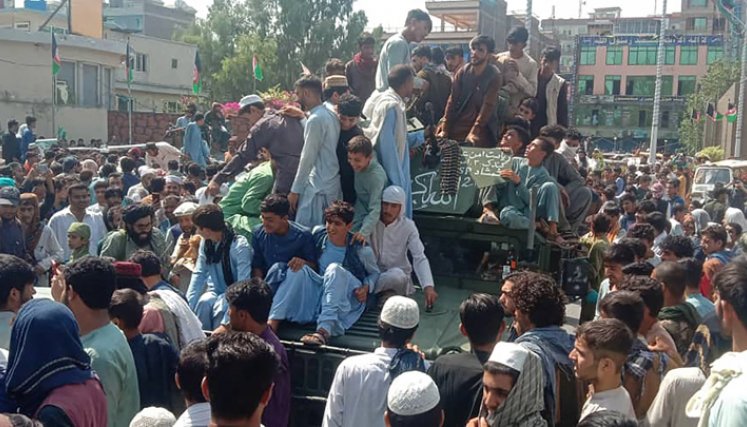 Los combatientes talibanes y la población local se sientan en un vehículo Humvee del Ejército Nacional Afgano (ANA) en una calle de la provincia de Jalalabad, el 15 de agosto de 2021. / Foto: AFP