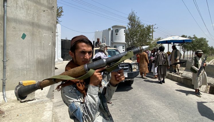Un combatiente talibán sostiene un cohete RPG mientras hace guardia con otros en una puerta de entrada fuera del Ministerio del Interior en Kabul. / Foto: AFP