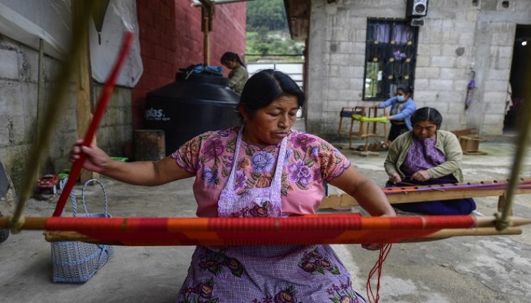 Tejedoras indígenas de un pueblo enclavado entre verdes cerros del sur de México. /AFP