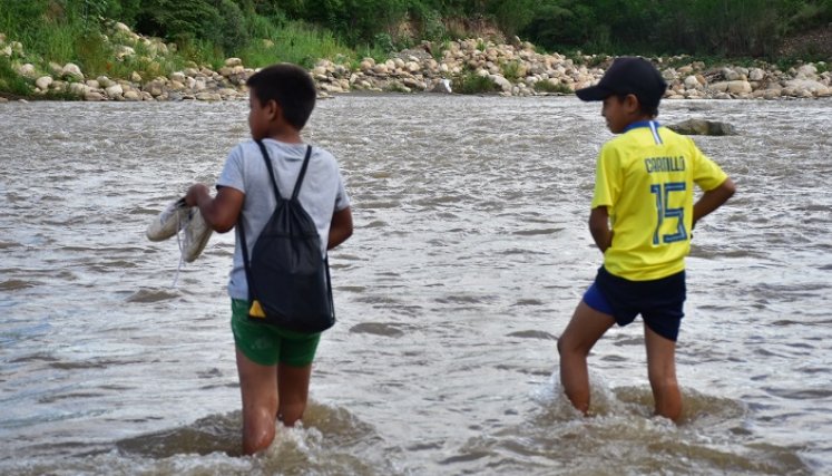 A diario, adultos y niños atraviesan el río para cumplir sus obligaciones.
