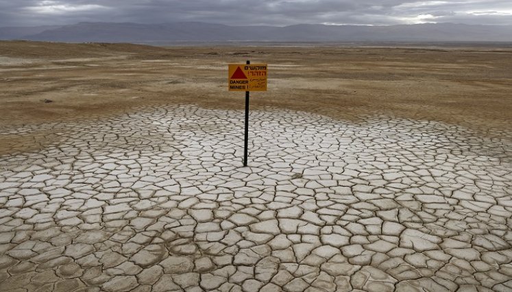 los tres kilómetros de arena rocosa que separan el spa de la orilla están hoy salpicados de agujeros y grietas./ AFP