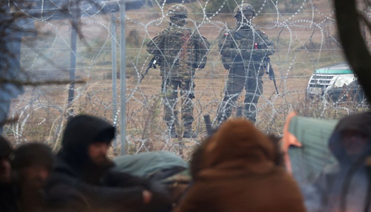 Militares polacos detrás de una cerca de alambre de púas en la frontera entre Bielorrusia y Polonia