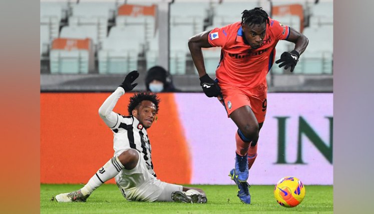 El centrocampista colombiano de la Juventus, Juan Cuadrado (derecha), lucha por el balón con el delantero colombiano del Atalanta, Duvan Zapata, durante el partido de fútbol de la Serie A italiana Juventus vs Atalanta en el Allianz Stadium de Turín. / Foto: AFP