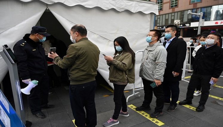 Personas hacen fila para recibir una inyección de refuerzo de la vacuna contra la Covid-19 en una tienda de campaña instalada fuera de un centro comercial en Beijing (China)./AFP