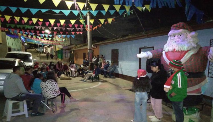 Los vecinos se congregan en torno al pesebre a rezar la novena. Foto: Cortesía/La Opinión.