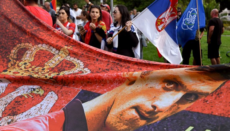 Los miembros de la comunidad serbia local sostienen banderas y pancartas frente a un centro de detención del gobierno donde el campeón de tenis de Serbia, Novak Djokovic, se encuentra en Melbourne el 8 de enero de 2022, luego de que se le negara dramáticamente la entrada a Australia por su estado de vacuna COVID-19.