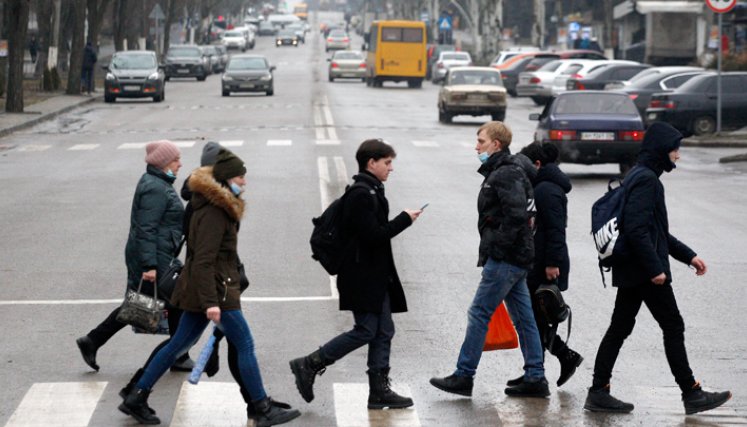 Los transeúntes caminan en un paso de peatones en la ciudad ucraniana de Kramatorsk, a unos 50 kilómetros de la línea del frente con los separatistas respaldados por Rusia. / Foto: AFP