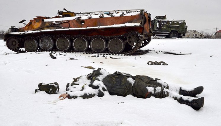 El cuerpo de un uniformado yace cerca de vehículos militares rusos destruidos al borde de la carretera en las afueras de Kharkiv, luego de la invasión rusa de Ucrania. La guerra empezó el 24 de febrero de 2022 y está generando miles de víctimas mortales, así como la mayor crisis de refugiados en el continente./Foto: AFP