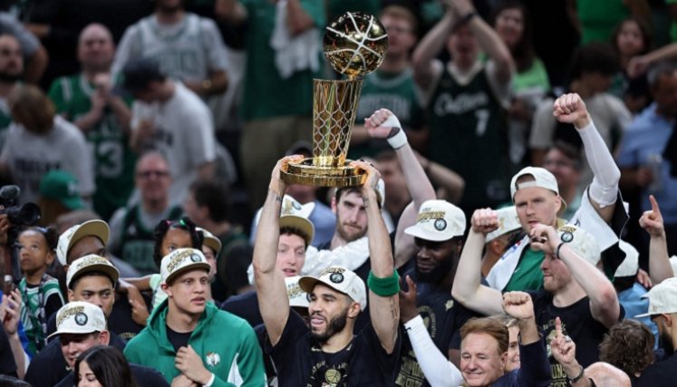 Jayson Tatum la estrella de los Celtics levanta el trofeo de campeón.