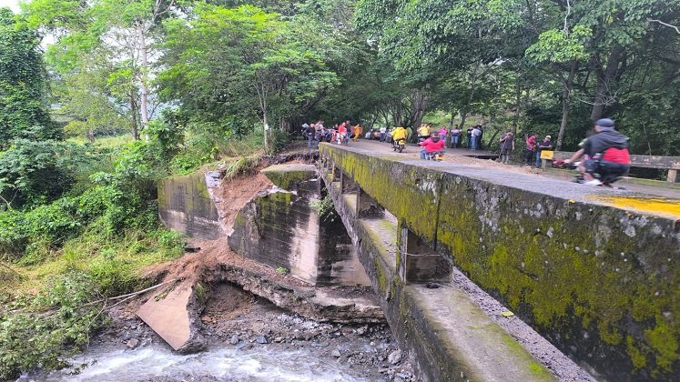 Técnicos especializados analizan la estructura del puente afectado por la ola invernal en el sector de La San Juana. /Foto: Cortesía.