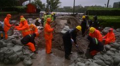 Un equipo prepara sacos de arena junto al río Yuyao en Ningbo, provincia de Zhejiang, en el este de China, este domingo, mientras el tifón In-Fa azota la costa este de China.