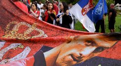 Los miembros de la comunidad serbia local sostienen banderas y pancartas frente a un centro de detención del gobierno donde el campeón de tenis de Serbia, Novak Djokovic, se encuentra en Melbourne el 8 de enero de 2022, luego de que se le negara dramáticamente la entrada a Australia por su estado de vacuna COVID-19.