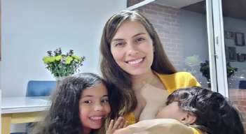 Angélica junto a sus dos hijas enseñando una gran sonrisa por la vocación de ser madre