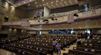 Un teatro de Bogotá abierto con pocas personas y sus sillas en mayoría con carteles que prohíbe sentarse por la situación de pandemia