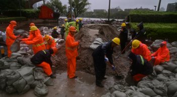 Un equipo prepara sacos de arena junto al río Yuyao en Ningbo, provincia de Zhejiang, en el este de China, este domingo, mientras el tifón In-Fa azota la costa este de China.