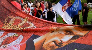 Los miembros de la comunidad serbia local sostienen banderas y pancartas frente a un centro de detención del gobierno donde el campeón de tenis de Serbia, Novak Djokovic, se encuentra en Melbourne el 8 de enero de 2022, luego de que se le negara dramáticamente la entrada a Australia por su estado de vacuna COVID-19.